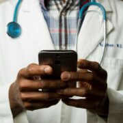Doctor holding smartphone symbolizing cybersecurity in healthcare and how to prevent password sharing